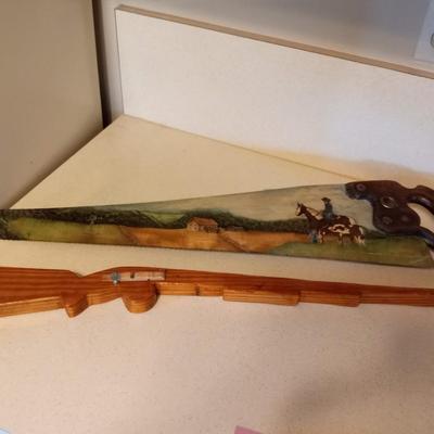 OIL PAINTING ON A HAND SAW, RUBBER BAND TOY GUN