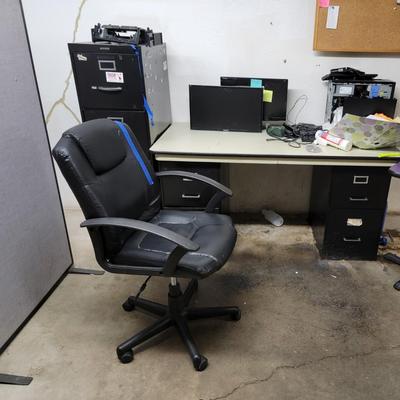 Desk and file cabinets, monitors, bulletin board, chair