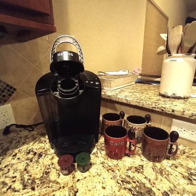 KEURIG COFFEE MAKER WITH REUSABLE FILTERS AND FOUR COFFEE CUPS WITH SPOON