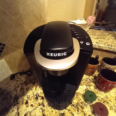 KEURIG COFFEE MAKER WITH REUSABLE FILTERS AND FOUR COFFEE CUPS WITH SPOON