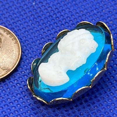 FAUX CAMEO PIN ON BLUE BACKGROUND