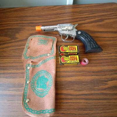 TOY CAPGUN IN LEATHER HOLSTER AND TWO BOXES OF ROLL CAPS