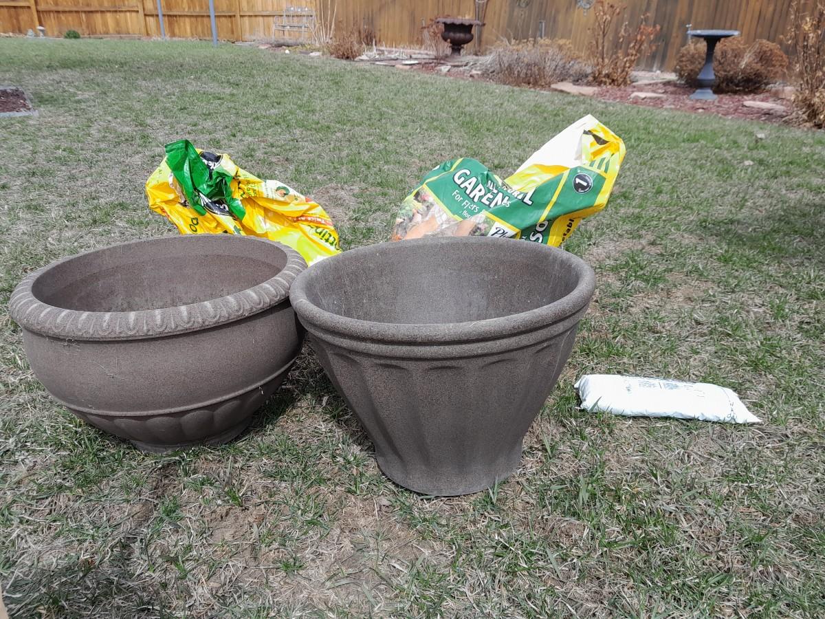 Two large plastic plant pots and partial bag of Natural garden soil