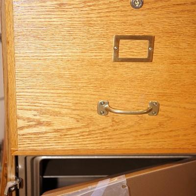 OAK TWO DRAWER FILE CABINET W/ CONCEALED SAFE BELOW.