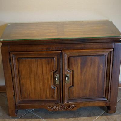 MODERN ASIAN STYLE TWO DOOR WOOD CABINET WITH BRASS PEDAL PULLS.