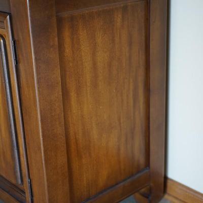 MODERN ASIAN STYLE TWO DOOR WOOD CABINET WITH BRASS PEDAL PULLS.