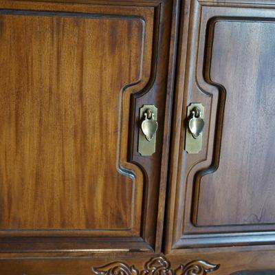 MODERN ASIAN STYLE TWO DOOR WOOD CABINET WITH BRASS PEDAL PULLS.