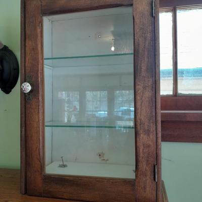 Antique wooden medicine cabinet with glass shelves