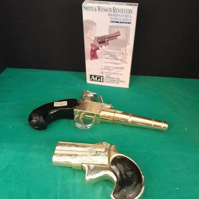 Two collectable Pistol Cologne bottles and a VHS on pistols