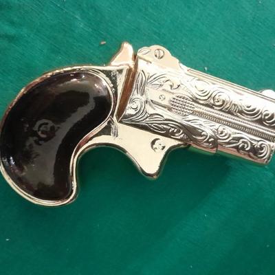 Two collectable Pistol Cologne bottles and a VHS on pistols