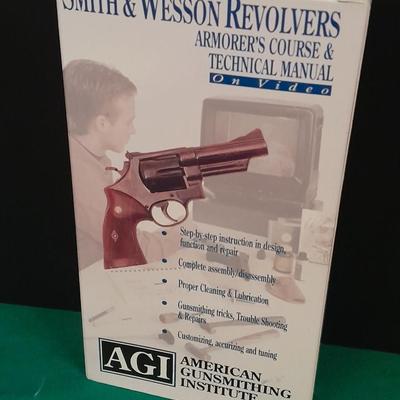 Two collectable Pistol Cologne bottles and a VHS on pistols