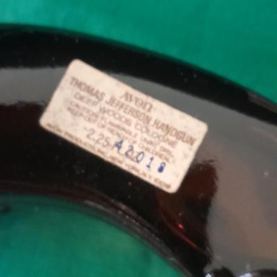 Two collectable Pistol Cologne bottles and a VHS on pistols