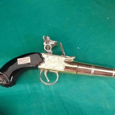 Two collectable Pistol Cologne bottles and a VHS on pistols