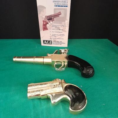 Two collectable Pistol Cologne bottles and a VHS on pistols