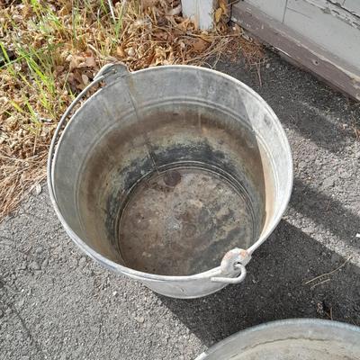 Two galvanized metal buckets and a shallow galvanized dish
