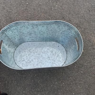 Wooden crate with Metal handled oval Ice tub, tall Fat tire beer bottles and Christmas brew 6 pack bottles.
