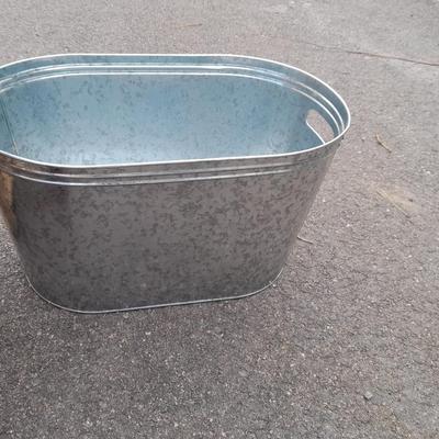Wooden crate with Metal handled oval Ice tub, tall Fat tire beer bottles and Christmas brew 6 pack bottles.
