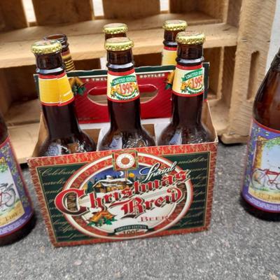 Wooden crate with Metal handled oval Ice tub, tall Fat tire beer bottles and Christmas brew 6 pack bottles.