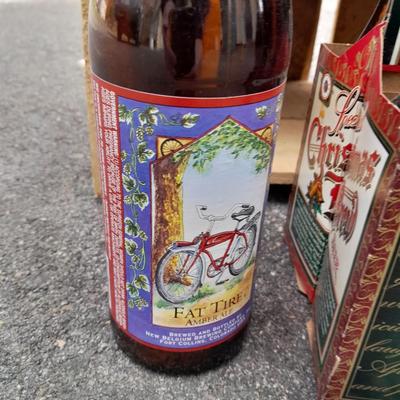 Wooden crate with Metal handled oval Ice tub, tall Fat tire beer bottles and Christmas brew 6 pack bottles.