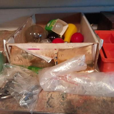 Tupperware organizer with lid, and an assortment of home hardware and lightbulbs