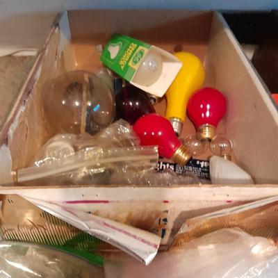 Tupperware organizer with lid, and an assortment of home hardware and lightbulbs