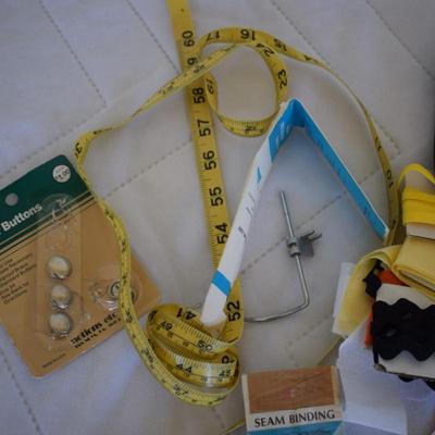 Tin of sewing notions.