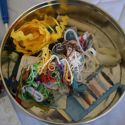 Tin of sewing notions.