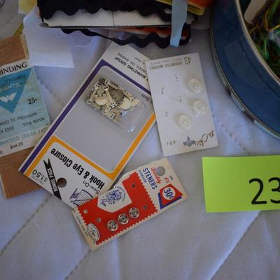 Tin of sewing notions.