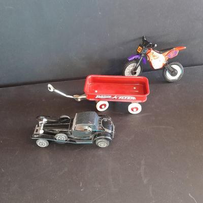 Motorcycle toy, radio flyer wagon, and black Riley MPH