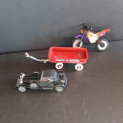 Motorcycle toy, radio flyer wagon, and black Riley MPH