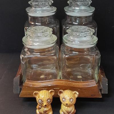 Four-piece lidded glass canister set on wooden Lazy Susan with vintage salt & pepper bear shakers