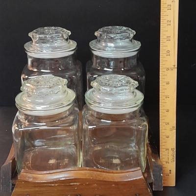 Four-piece lidded glass canister set on wooden Lazy Susan with vintage salt & pepper bear shakers