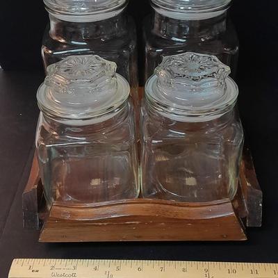 Four-piece lidded glass canister set on wooden Lazy Susan with vintage salt & pepper bear shakers