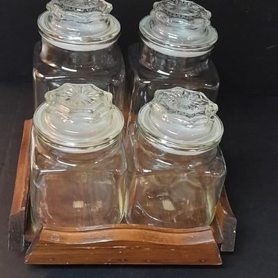 Four-piece lidded glass canister set on wooden Lazy Susan with vintage salt & pepper bear shakers