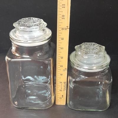 Four-piece lidded glass canister set on wooden Lazy Susan with vintage salt & pepper bear shakers