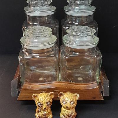 Four-piece lidded glass canister set on wooden Lazy Susan with vintage salt & pepper bear shakers