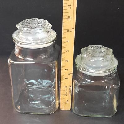 Four-piece lidded glass canister set on wooden Lazy Susan with vintage salt & pepper bear shakers