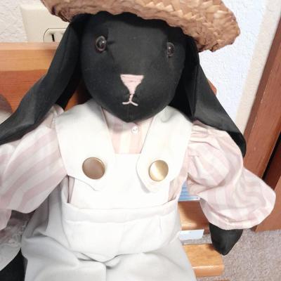 Wooden doll bench with two rabbits and a framed picture