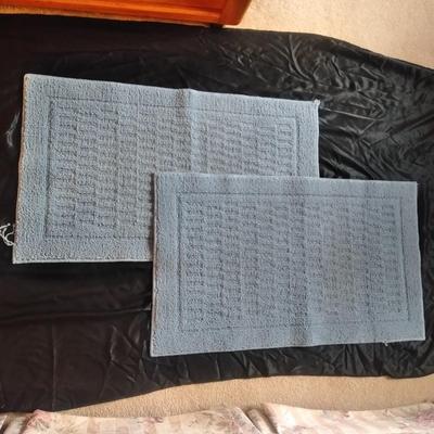 Two bath rugs, towels, hand towels, toothbrush holder and handheld mirror
