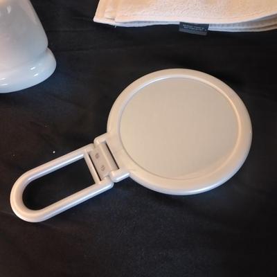 Two bath rugs, towels, hand towels, toothbrush holder and handheld mirror