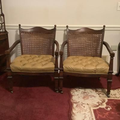Lot 529. Pair of Vinyl Covered Cane Back Arm Chairs on Wheels