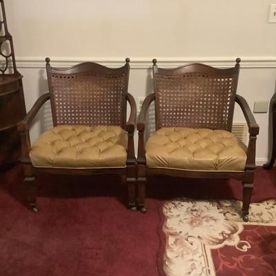 Lot 529. Pair of Vinyl Covered Cane Back Arm Chairs on Wheels