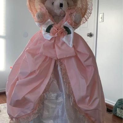 stuffed bear in pretty dress with hat on stand