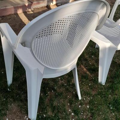Three white plastic Patio chairs