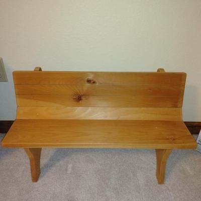 Two crafted cow dolls and a pig doll on a wooden bench