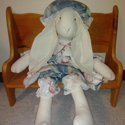 Four handcrafted bunnies and a wooden bench