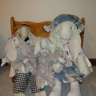 Four handcrafted bunnies and a wooden bench