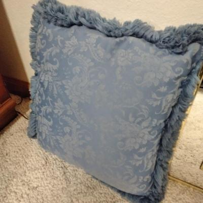 Two throw pillows and a gold framed wall mirror