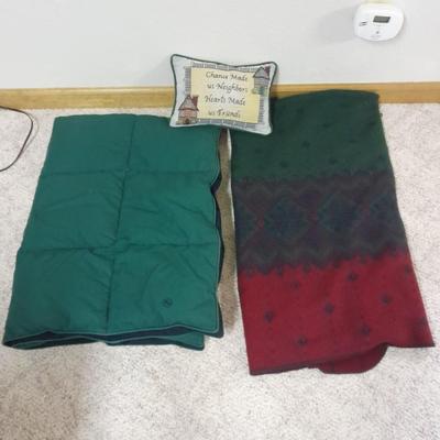 Two throw blankets, one down and a throw Pillow