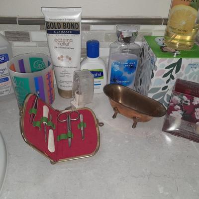 Box of hair curlers, nail care kit, soaps, lotions, Kleenex, perfumes, and brass bathtub soap holder